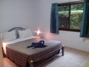a robe on a bed in a bedroom with a window at Sabai Residence in Ao Nang Beach