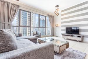 a living room with a couch and a tv at Icon Casa Living - The Residence Tower 5 in Dubai