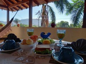 a table with plates of food and glasses of wine at Pousada Casa Grande in Barra do Garças