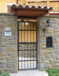 une porte en fer dans un bâtiment en pierre avec un panneau dans l'établissement Torrente Rosandra, à San Dorligo della Valle