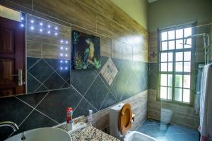 a bathroom with a sink and a toilet and a window at Kinga Homes Boutique Hotel in Moshi