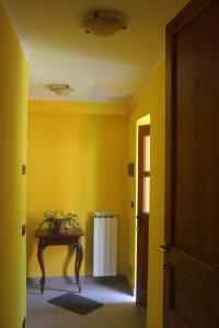 a hallway with a table and a yellow wall at Torrente Rosandra in San Dorligo della Valle