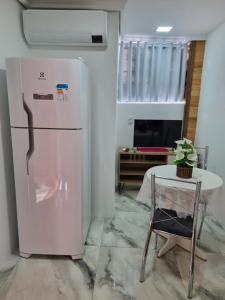 a white refrigerator in a room with a table at Casa elmar in Canela +8 photos