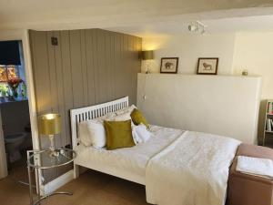 a bedroom with a bed with white sheets and pillows at Church Farm House in Cirencester