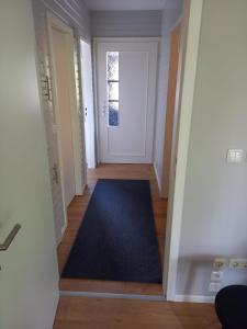 un corridoio con una porta e un tappeto blu di THE IVY a Wittingen