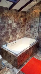 a bath tub with a glass shower in a bathroom at Havenwood in Ayr