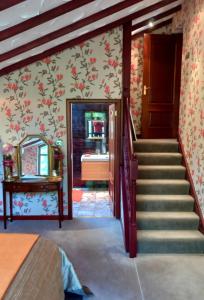 a staircase in a bedroom with floral wallpaper at Havenwood in Ayr