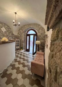 a living room with a chair and a stone wall at Regnos Altos boutique rooms in Bosa