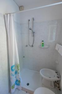 a bathroom with a shower and a toilet and a sink at Hotel Casa Adolfo Ischia in Ischia