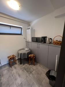 eine kleine Küche mit einem Tisch und einer Mikrowelle in der Unterkunft Vila Dan in Galaţi