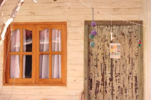 a window of a wooden house with a curtain at Cielito Lindo in Cafayate