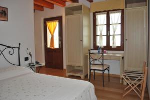 een slaapkamer met een bed, een bureau en ramen bij Ciase dal Orcul in Cormòns