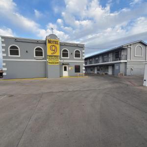 ein Parkplatz vor einem Gebäude mit einem Motelschild in der Unterkunft Motel 9 in Laredo