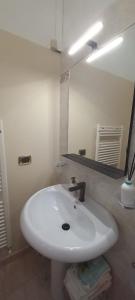 y baño con lavabo blanco y espejo. en La Maison à la Mer - Appartamentino a 200 mt dal mare, en Giulianova