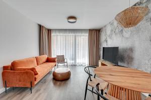 グダニスクにあるGdańsk Comfort Apartaments Łąkowaのリビングルーム(ソファ、テーブル付)