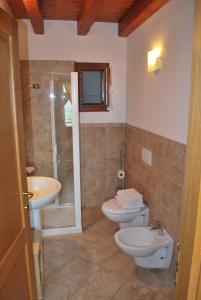 a bathroom with two toilets and a shower and a sink at Ciase dal Orcul in Cormòns