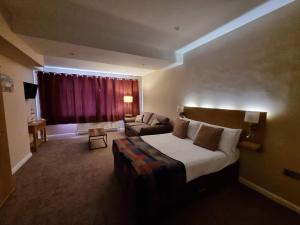 a hotel room with a bed and a couch at The Ramleh in Scarborough