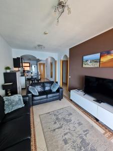 a living room with a couch and a flat screen tv at Four Seasons - Playa del Cura in Playa del Cura