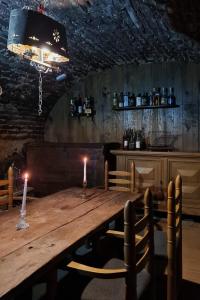 una mesa de madera en un restaurante con dos velas en Vila cu Ciubar & Jacuzzi - Sunset Hill House, en Cuvin