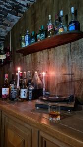 un bar con botellas de alcohol en una barra de madera en Vila cu Ciubar & Jacuzzi - Sunset Hill House, en Cuvin