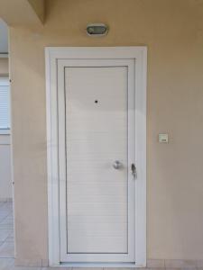 a white door with a silver knob on a wall at Markella's Studio in Kavála