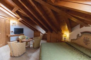 Schlafzimmer mit einem grünen Bett und einem Schreibtisch in der Unterkunft Hotel Europa Residence in Asiago