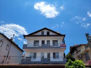 ein weißes Gebäude mit einem Balkon darauf in der Unterkunft Cetin Pansiyon in Fethiye