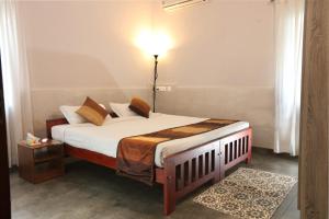 1 dormitorio con 1 cama con lámpara. en Monsoon Apartments, en Kannur