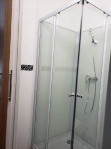 a shower with a glass door in a bathroom at hotel de la gare in Modane +31 photos