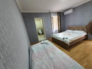 een slaapkamer met 2 bedden en een spiegel bij Lime Hill Hotel in Koetaisi