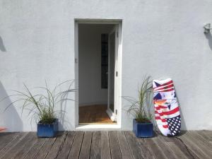 an open door with two potted plants on a deck at Beautiful Holiday Home in Schull in Schull