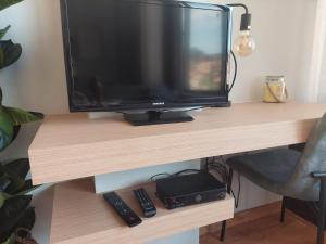 a television sitting on a desk with two remote controls at Charming Central Studio with AC in Porto