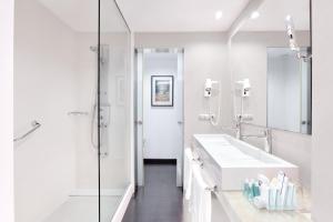 a white bathroom with a sink and a shower at Hotel Cristina by Tigotan Las Palmas - Adults Only in Las Palmas de Gran Canaria