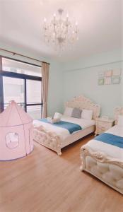 a bedroom with two beds and a chandelier at Princess Chloe B&B in Hengchun