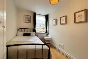 een slaapkamer met een bed en een raam bij Lisa's Place near Kings Cross - 2 Double Beds, 1 Sofa Bed, Great Location, Ideal for Families in Londen