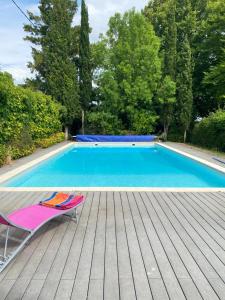 uma cadeira sentada num deque ao lado de uma piscina em Demeure de 7 chambres avec piscine privee jardin clos et wifi a Chaniers em Chaniers