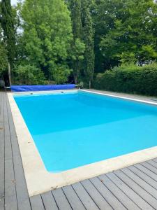 duży niebieski basen na drewnianym tarasie w obiekcie Manoir majestueux à Chaniers avec piscine privée w mieście Chaniers
