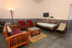 a living room with a couch and chairs at Monsoon Apartments in Kannur