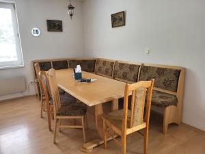 a dining room with a wooden table and a couch at Dom Bystrá pod Chopkom & wellness in Bystrá