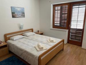 a bedroom with a large bed with two pillows on it at Valica Gardens in Savudrija