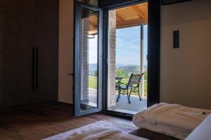 um quarto com uma porta que abre para um pátio com uma cadeira em Villa de Vino em Ioannina
