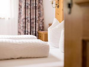 sypialnia z 2 łóżkami z białą pościelą i oknem w obiekcie Apartment Kraxner w Solden