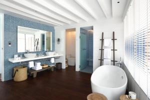 un bagno con due lavandini e una grande vasca di COMO Cocoa Island a Città di Malé