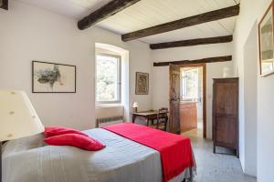 ein Schlafzimmer mit einem Bett mit einer roten Decke in der Unterkunft Les Pieds dans la Beaume in Joyeuse