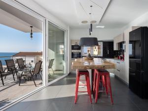 una cucina con tavolo in legno e sgabelli rossi di View Point Apartment a Chania