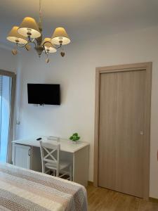 1 dormitorio con escritorio, mesa y TV en Guest House Bellavista Nebida, en Nebida