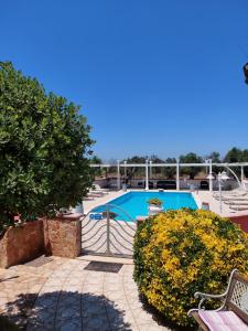 a swimming pool with a bench and some bushes at B&B ARTHAS in Capilungo
