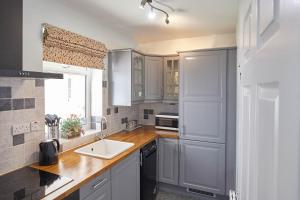 eine Küche mit weißen Schränken und einem Waschbecken in der Unterkunft Host & Stay - The Haven in Whitby