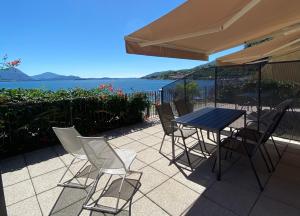a table and chairs on a patio with a view of the water at Regina e Oriente - La casa del Moro in Baveno