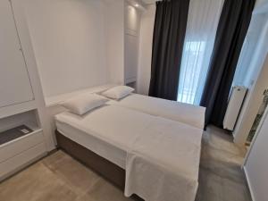 a white bed in a room with a window at Ikarus Modern Apartment at the Centre of Athens in Athens